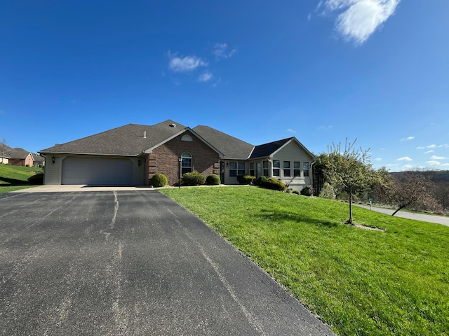 ranch-style home featuring a front yard, a garage, aphalt driveway, brick siding, and roof with shingles