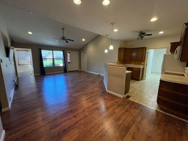 kitchen featuring ceiling fan, recessed lighting, light countertops, open floor plan, and light wood finished floors