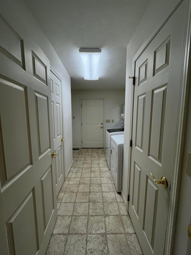 washroom featuring washer and dryer, laundry area, and stone tile floors