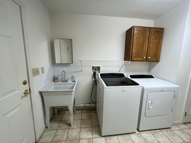 washroom with cabinet space, stone finish floor, and separate washer and dryer