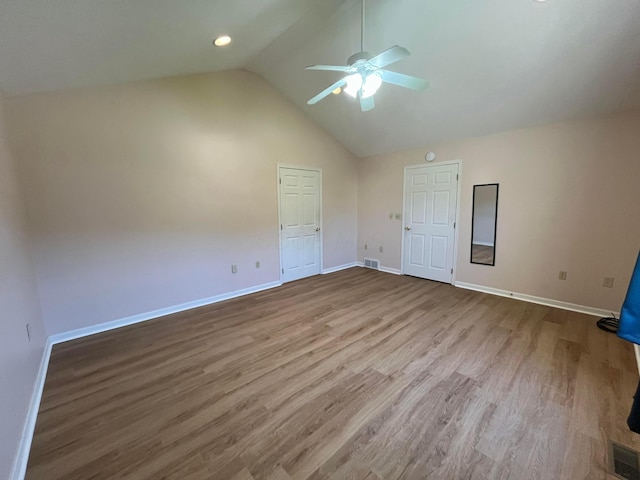 unfurnished bedroom with visible vents, baseboards, high vaulted ceiling, and wood finished floors