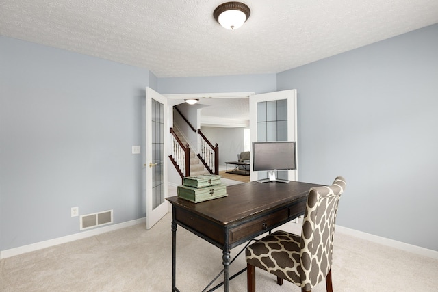 office space featuring light colored carpet, a textured ceiling, baseboards, and french doors