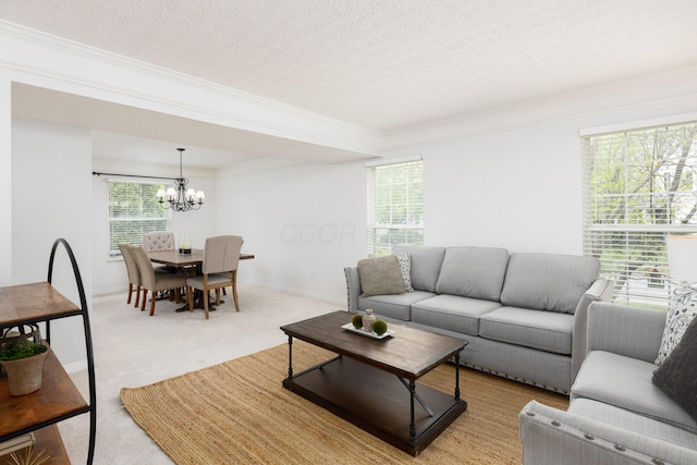 living area featuring a chandelier, crown molding, carpet, and a textured ceiling