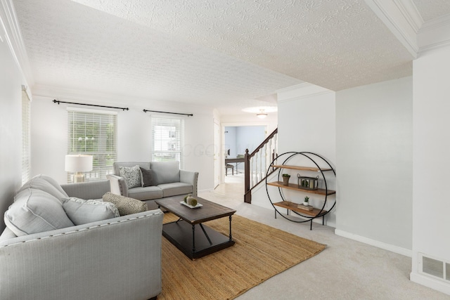 living room featuring ornamental molding, carpet flooring, stairway, and a textured ceiling