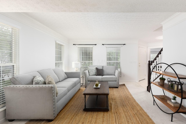 living room featuring stairway, ornamental molding, and a textured ceiling