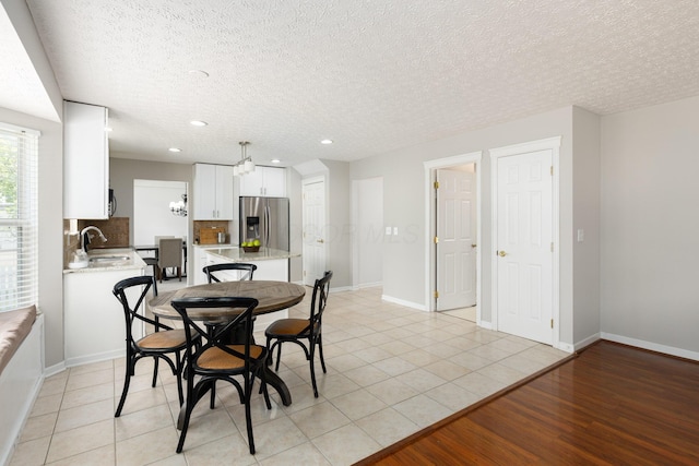 dining area with recessed lighting, a textured ceiling, baseboards, and light tile patterned floors