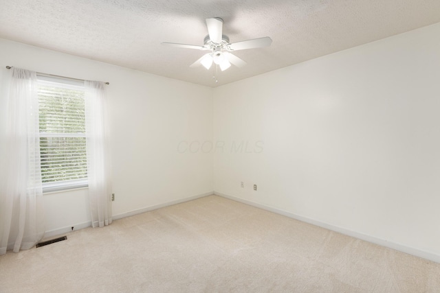 carpeted spare room featuring ceiling fan, baseboards, and a textured ceiling