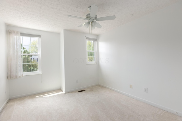 unfurnished room featuring carpet, a ceiling fan, a textured ceiling, and baseboards