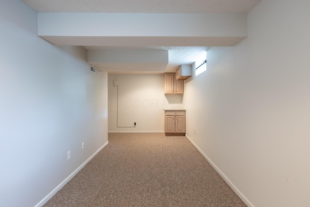 corridor featuring baseboards and light colored carpet