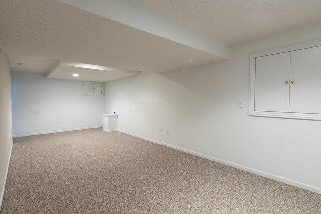 finished basement featuring carpet floors, baseboards, a textured ceiling, and recessed lighting