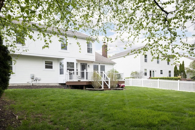 back of property featuring a wooden deck, a chimney, and roof with shingles