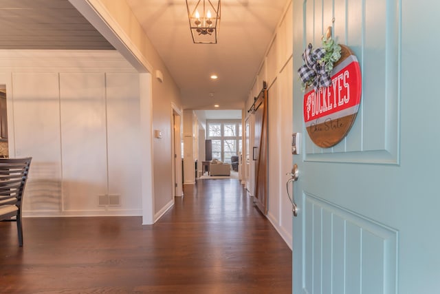 foyer entrance with an inviting chandelier, visible vents, recessed lighting, a barn door, and dark wood-style flooring