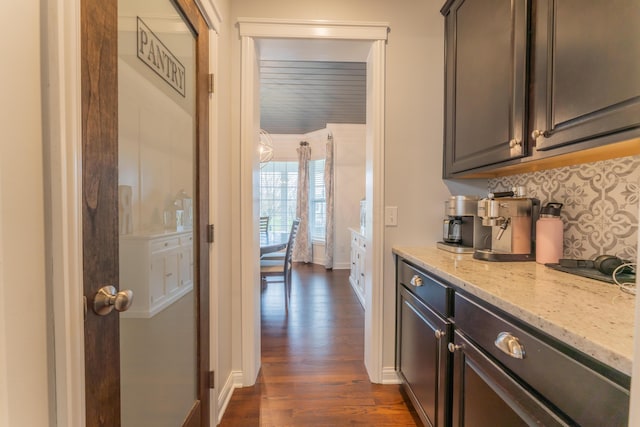 interior space featuring dark wood-type flooring, tasteful backsplash, and baseboards