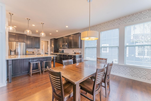 dining space with wallpapered walls, baseboards, dark wood finished floors, and recessed lighting