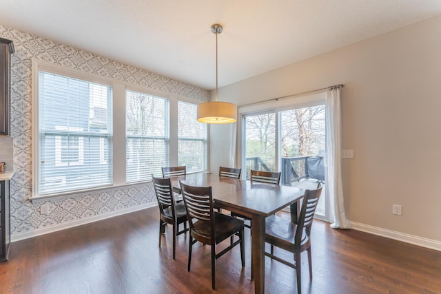 dining area featuring dark wood-style flooring, baseboards, a healthy amount of sunlight, and wallpapered walls