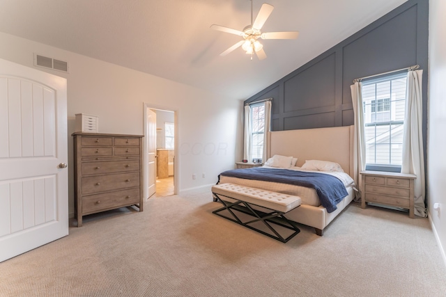 bedroom with visible vents, ensuite bathroom, a ceiling fan, vaulted ceiling, and light carpet