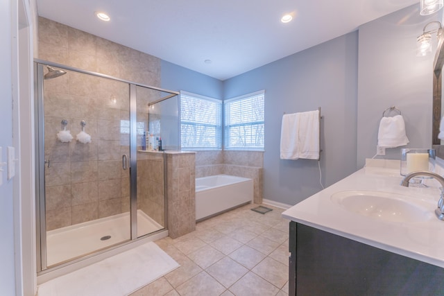 full bath with a sink, double vanity, a stall shower, tile patterned flooring, and a garden tub