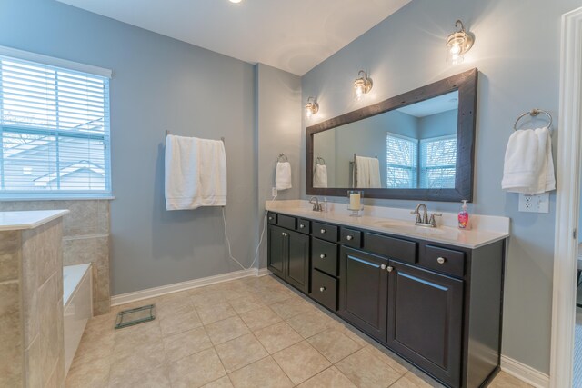 full bathroom with double vanity, a sink, tile patterned flooring, and baseboards