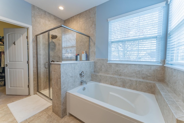 full bathroom with a shower stall, a bath, tile patterned flooring, and a walk in closet