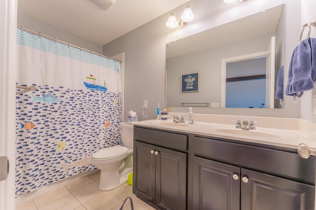 full bath with tile patterned floors, double vanity, a sink, and toilet