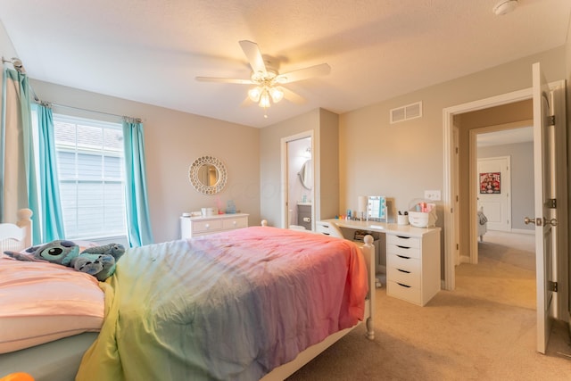 bedroom featuring light carpet, ensuite bath, a ceiling fan, and visible vents