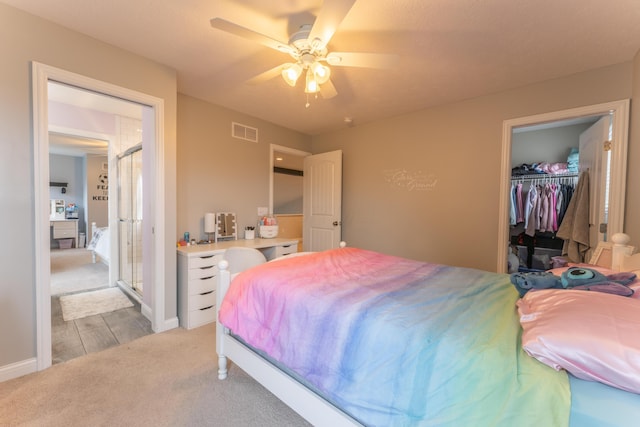 bedroom with visible vents, a closet, a spacious closet, ceiling fan, and light colored carpet