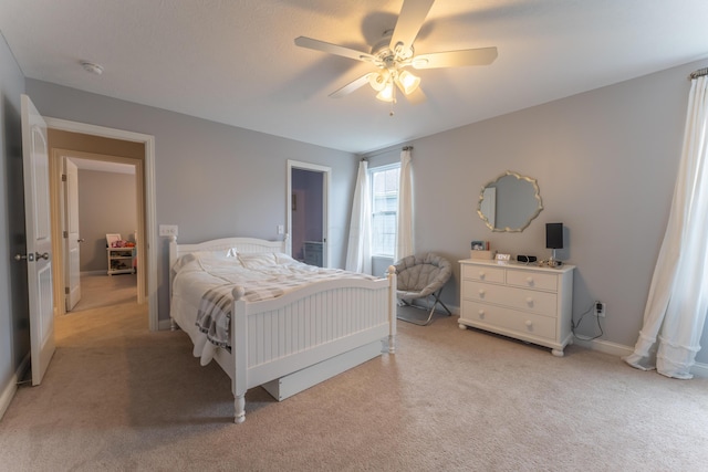 bedroom featuring ceiling fan, light carpet, and baseboards