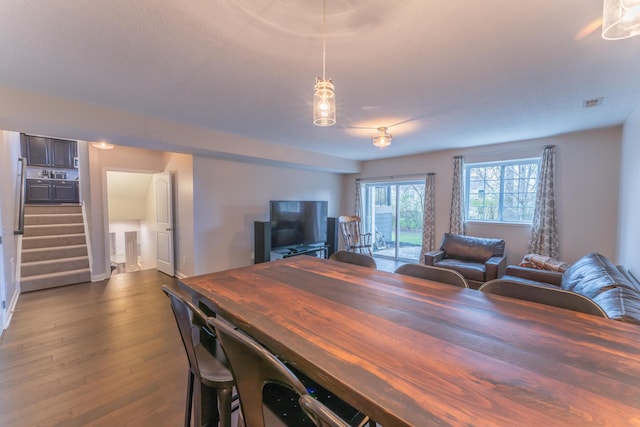 dining space featuring stairway, dark wood-style floors, and visible vents