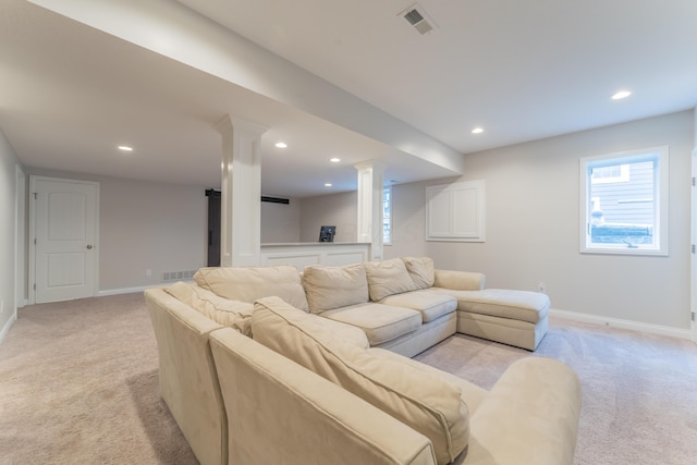 living room with visible vents, baseboards, ornate columns, and light colored carpet
