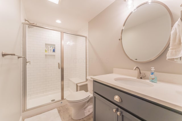 bathroom featuring toilet, vanity, and a stall shower