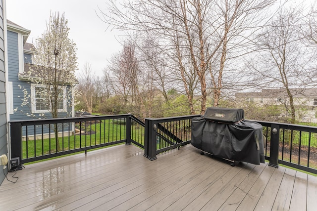 wooden deck featuring area for grilling and a lawn
