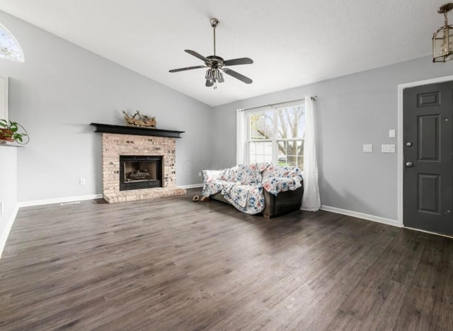 living area featuring a fireplace, a ceiling fan, baseboards, lofted ceiling, and dark wood-type flooring