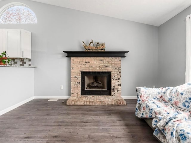 living room with baseboards, dark wood-style floors, and vaulted ceiling