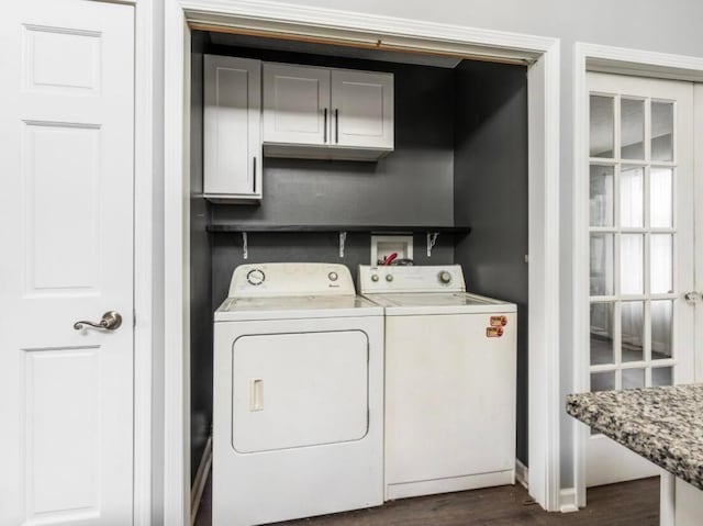 washroom with dark wood-type flooring, cabinet space, and washer and dryer