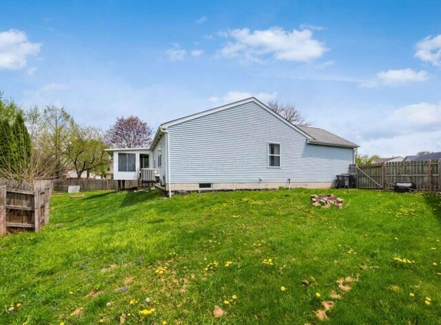back of house featuring a yard and a fenced backyard