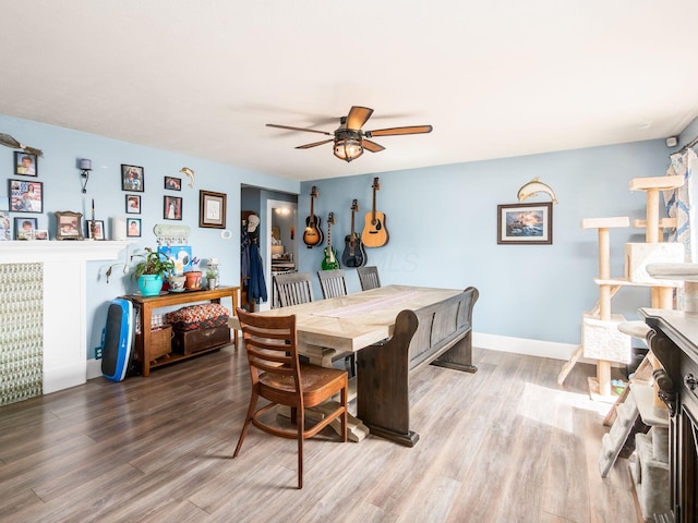 dining space with baseboards, wood finished floors, and a ceiling fan