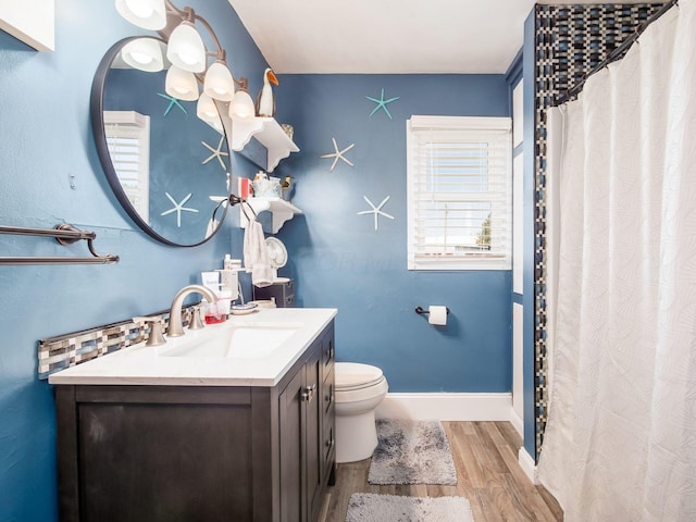 bathroom with toilet, baseboards, a shower with shower curtain, vanity, and wood finished floors