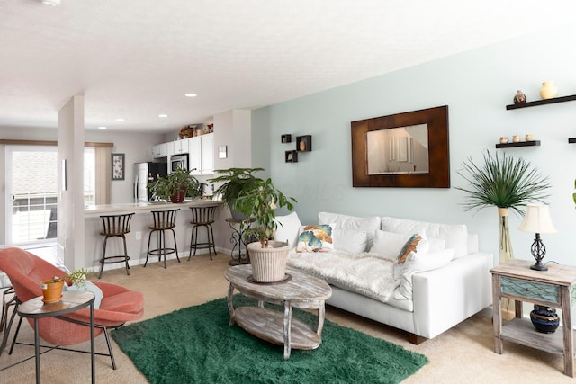 living area featuring recessed lighting and light carpet
