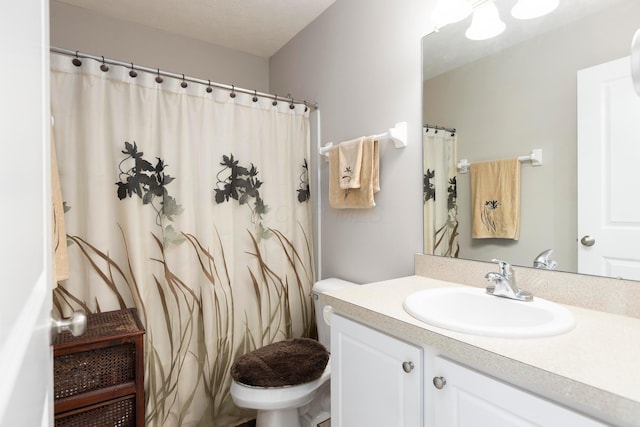 bathroom featuring toilet, vanity, and a shower with shower curtain