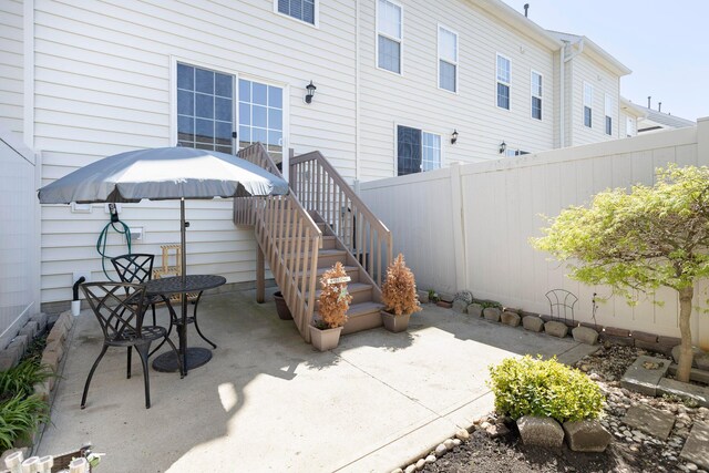 view of patio with fence and stairs