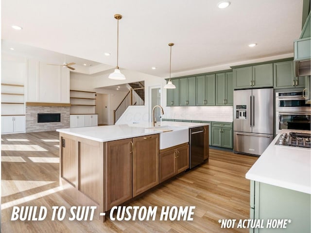 1736 Harvey Ln, Grove City, OH 43123 - kitchen featuring a sink, light wood-type flooring, green cabinets, light countertops, and appliances with stainless steel finishes