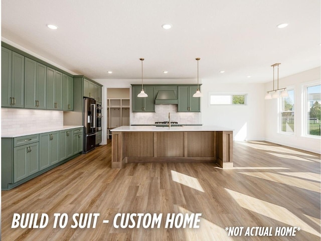 1736 Harvey Ln, Grove City, OH 43123 - kitchen with light countertops, high end fridge, wall chimney exhaust hood, green cabinets, and decorative backsplash