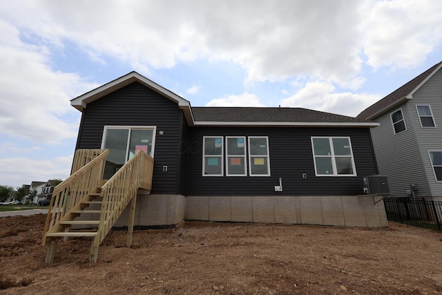 manufactured / mobile home with fence, central AC unit, and roof with shingles