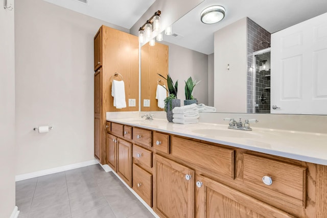 bathroom with a sink, double vanity, tile patterned flooring, and tiled shower