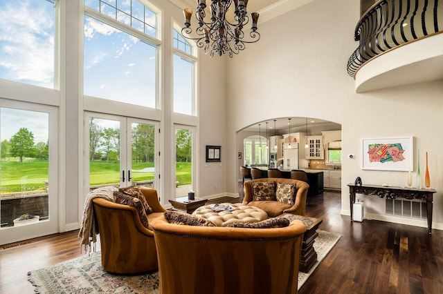 10577 Wellington Blvd, Powell, OH 43065 - living room with arched walkways, a towering ceiling, plenty of natural light, dark wood-style flooring, and crown molding