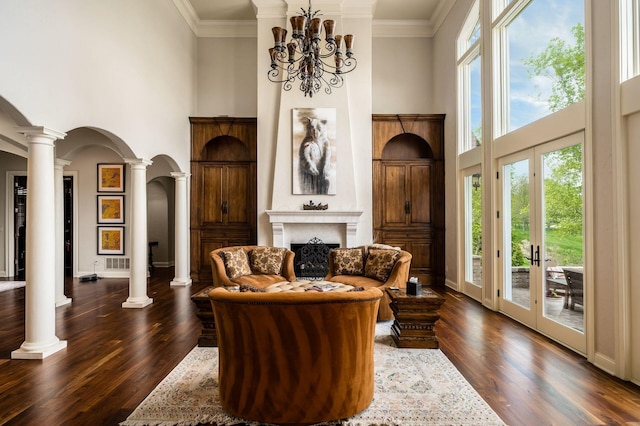 10577 Wellington Blvd, Powell, OH 43065 - living area featuring a towering ceiling, decorative columns, arched walkways, a fireplace, and dark wood-style floors