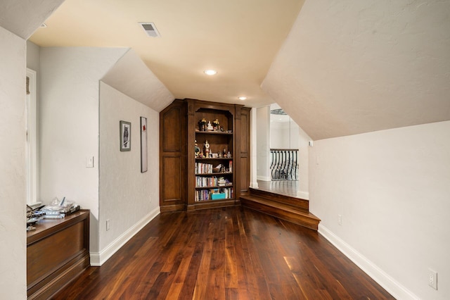 10577 Wellington Blvd, Powell, OH 43065 - additional living space featuring dark wood finished floors, vaulted ceiling, baseboards, and built in features