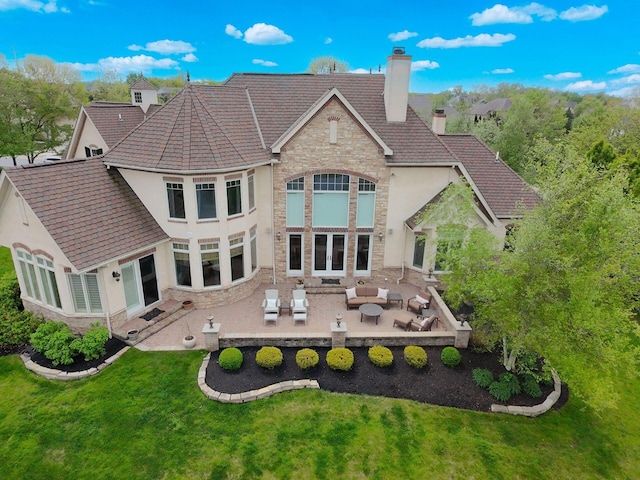 10577 Wellington Blvd, Powell, OH 43065 - back of house with outdoor lounge area, stone siding, stucco siding, a chimney, and a lawn