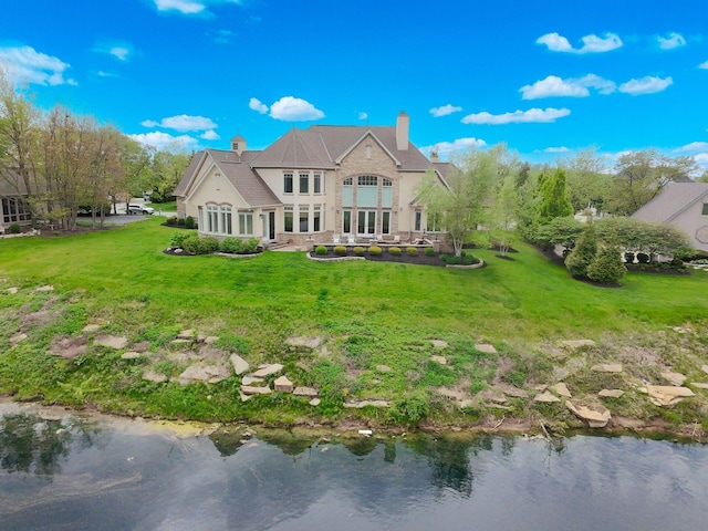 10577 Wellington Blvd, Powell, OH 43065 - rear view of property featuring a chimney, a yard, stucco siding, and a water view