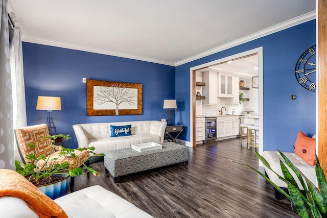living room featuring beverage cooler, dark wood-type flooring, ornamental molding, and baseboards